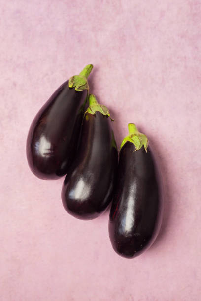 istock Closeup of eggplants on a pink background 1395742135