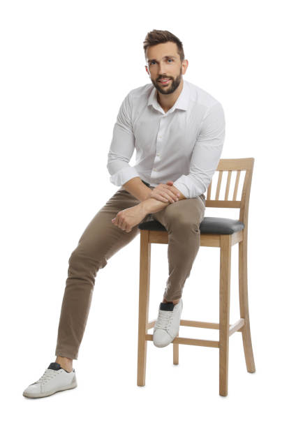 istock Handsome man sitting on stool against white background 1395742137
