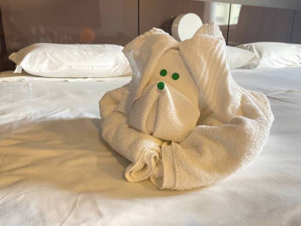 Dog-shaped bath towel on the bed sheet.