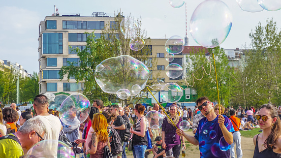 Berlin, Germany-May 2018: Street artist, the entertainer, performing outdoor, making big, beautiful and colourful water bubbles and selling his handmade product, giving joy to the kinds and other people.