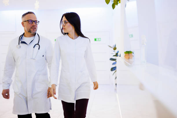 istock Two Doctors talking As They Walk Through Hospital 1395746006