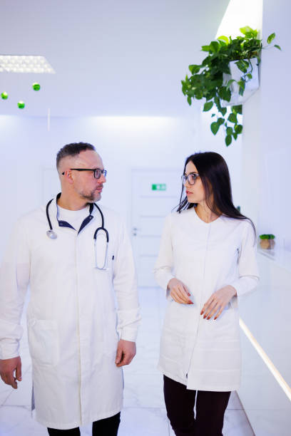 istock Doctors Talking As They Walk in Hospital 1395746578