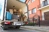 istock Van full of moving boxes and furniture near house 1395748211