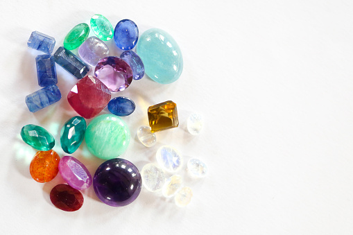 Close-up of a group of various colorful gemstones on white background.