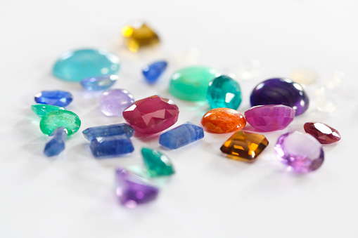 Close-up of a group of various colorful gemstones on white background.