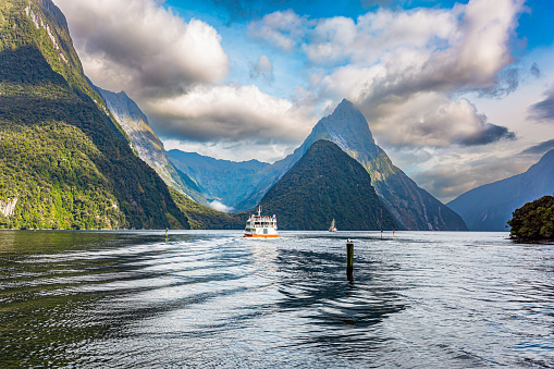 New Zealand. South Island. Tourist boat in the smooth water of the Milford Sound. Fiordland park.The magical nature of the southern hemisphere.
