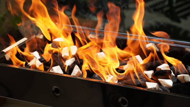 istock Empty Barbecue Flaming Grill Close Up With Bright Flames And White firelighters burning 1395755260