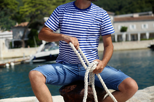 Adult male sailor in a yacht marina. Unrecognizable Caucasian male.