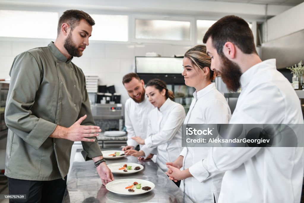 Female Experiencing Ration Critique By Judge During Cooking Competition A Helping Hand Stock Photo