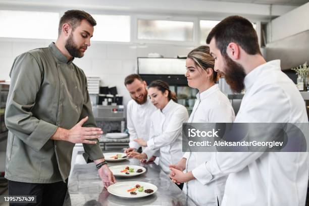 Female Experiencing Ration Critique By Judge During Cooking Competition Stock Photo - Download Image Now