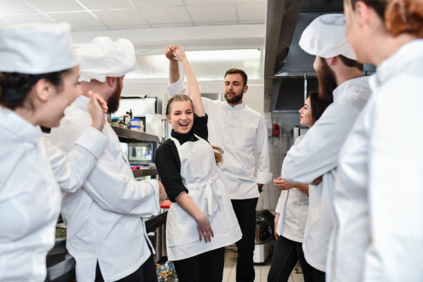 istock Smiling Waitress Dancing With Chef In Restaurant 1395757493
