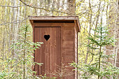 Wooden outdoor toilet with heart on the door.