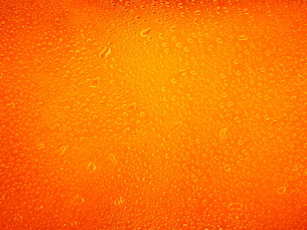 istock Water drops on orange background texture. backdrop glass covered with drops of water 1395759655