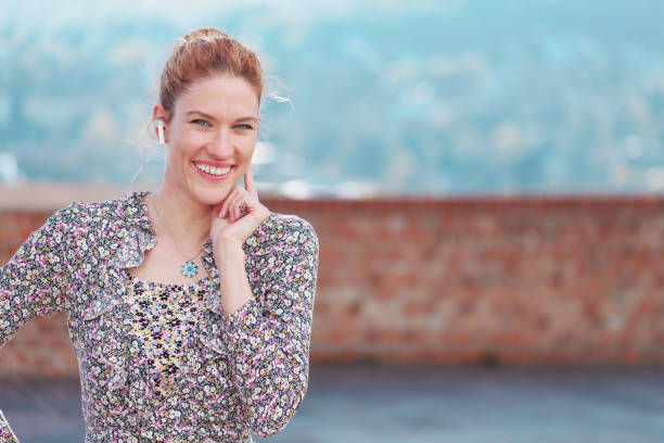 istock Young redhead woman with hands free device toothy smiling empty space 1395760618