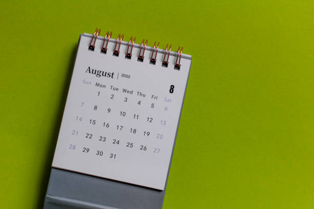 istock Desktop calendar for August 2022 on a green background. 1395760747