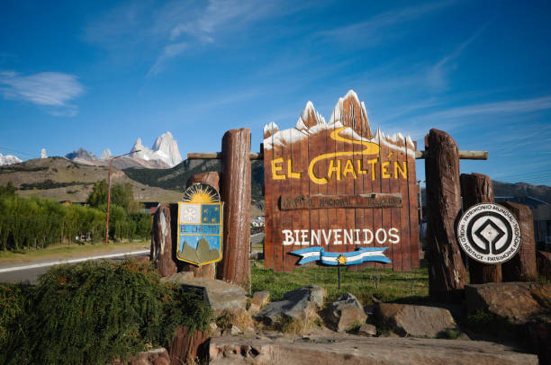 Welcome sign with emblem of El Chalten - capital of trekking in Patagonia, Argentina Welcome sign with emblem of El Chalten - capital of trekking in Patagonia, Argentina. Summit of Mount Fitz Roy is on left. Wooden signboard with El Chalten Bienvenidos inscription means Welcome fitzroy range stock pictures, royalty-free photos & images