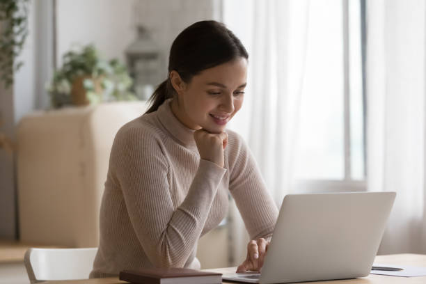 istock Young woman sit at table in domestic kitchen using laptop 1395762583