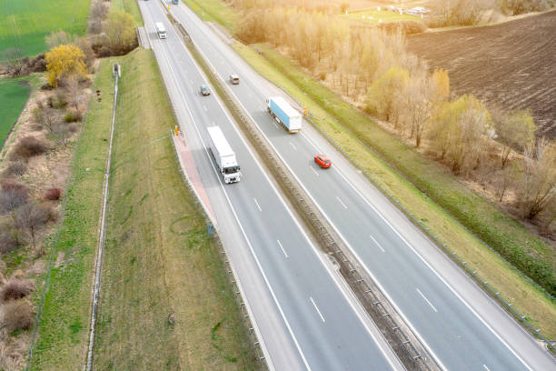 istock Many trucks are moving along the highway crossing road between the fields. drone view. 1395763704