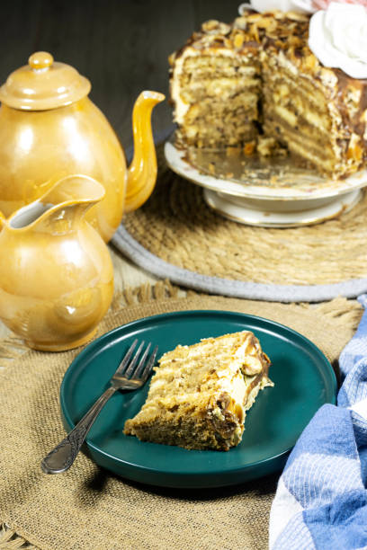 istock Birthday layer cake  with chocolate pieces and hazelnuts and almonds on green plate with coffee and milk 1395764655
