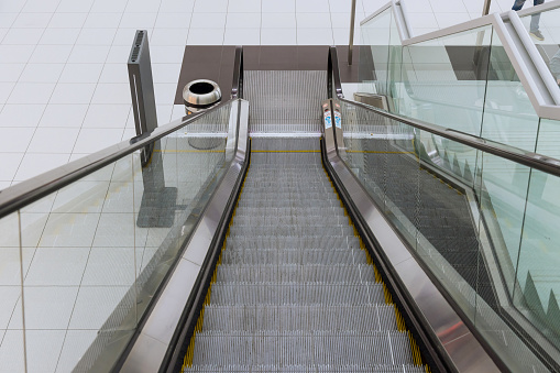 Escalator in the International Airport building with moving staircase