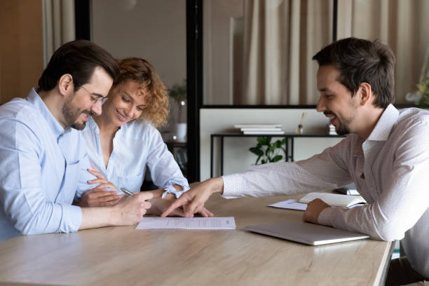 Happy couple of clients signing house buying, rent contract stock photo
