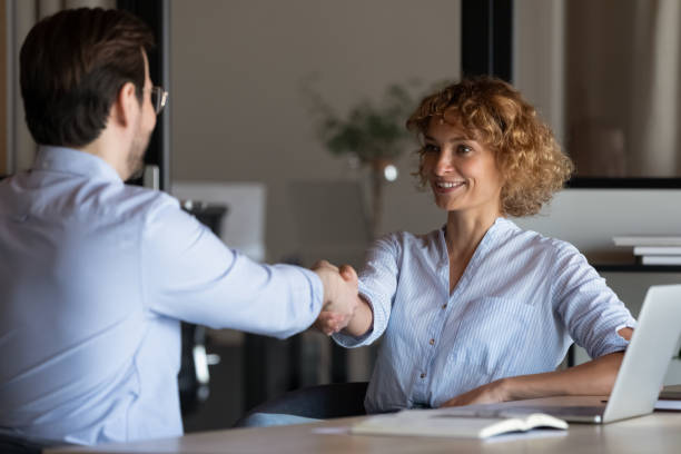 istock Happy confident young businesswoman shaking hands with client 1395769881