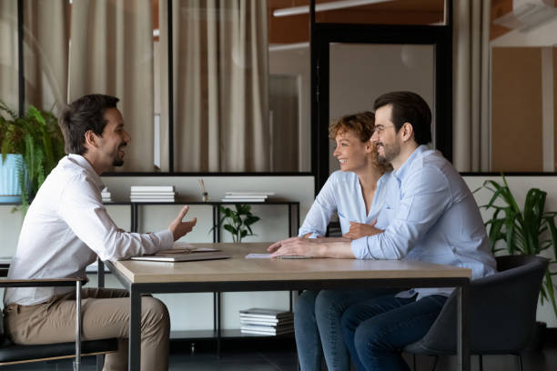 heureux couple familial de clients rencontrant un agent immobilier - lawyer family talking discussion photos et images de collection