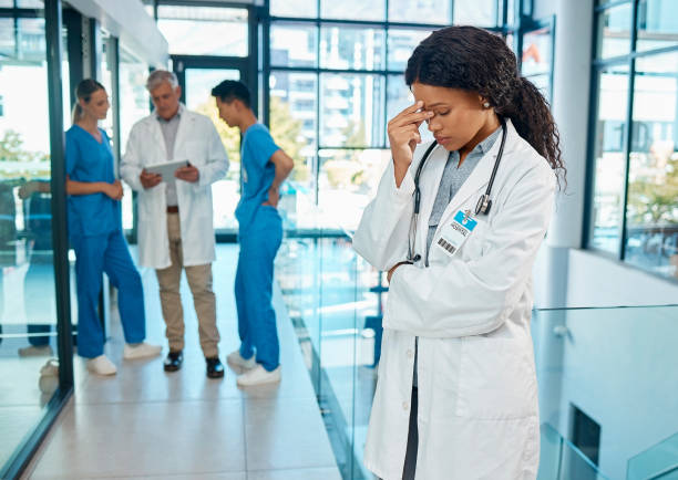 scatto di una giovane dottoressa affetta da mal di testa in un ospedale moderno - senior women defeat headache pain foto e immagini stock