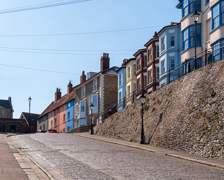 Colourfully painted houses at the top of a cobbled slope or slipway which leads to the beach in Cromer, Norfolk, Eastern England.