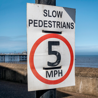 A sign on the beachside promenade at Cromer in Norfolk, Eastern England, which reads “Slow Pedestrians 5mph” as a warning to any vehicles which might also be using the promenade.