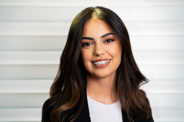 foto de estudio de una hermosa mujer de 20 años con una bonita sonrisa y aparatos dentales - young women smiling women human teeth fotografías e imágenes de stock