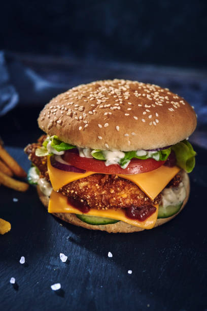 istock Crispy Chicken Burger with Cheese, Tomato, Onions and Green Salad 1395775229