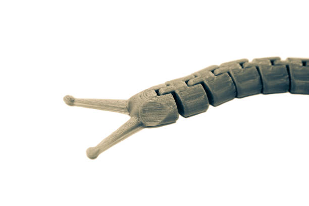 istock Bright light brown object in shape of caterpillar toy printed on 3d printer 1395775462
