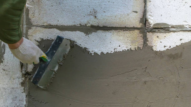 istock Plastering cement at wall for renovation house. Plasterer smoothing plaster on wall. Putty brick wall background 1395781174