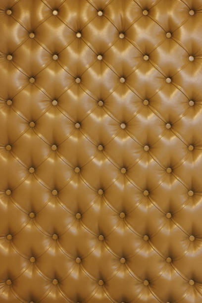 Texture of brown beige leather background with capitone pattern, full-frame. Brown retro Chesterfield style.