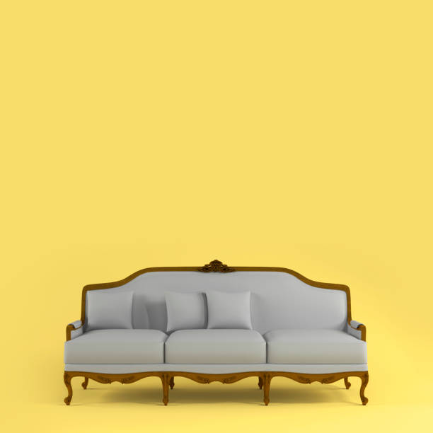 istock Classic gray fabric sofa with carved decorative elements and soft pillows on yellow background. Furniture, interior object, Fabric elegant sofa. Color of year 2021. Illuminating and Ultimate gray 1395782871