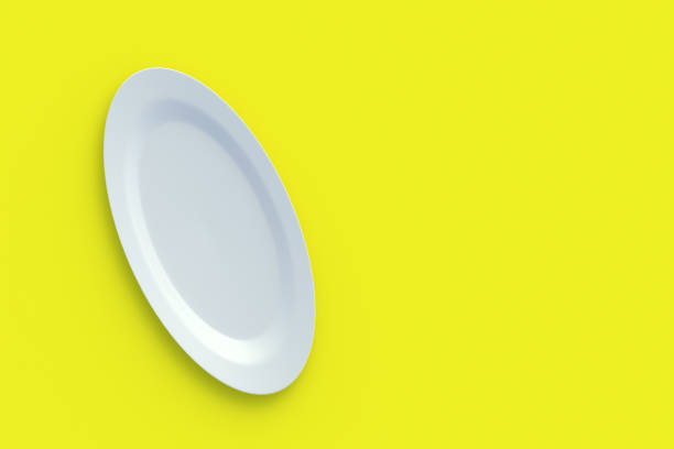 istock White oval plate on yellow background. Top view. Copy space. 3d render 1395784894