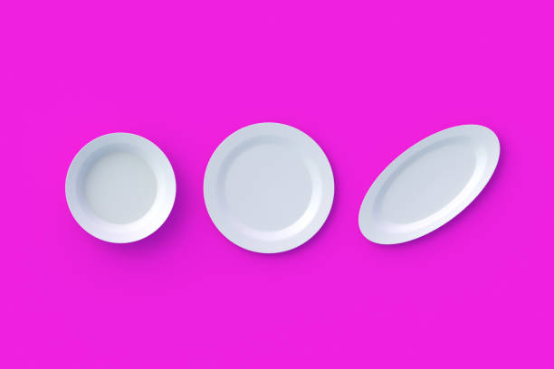 istock Set of different empty white plates on rose background. Top view. 3d render 1395784912
