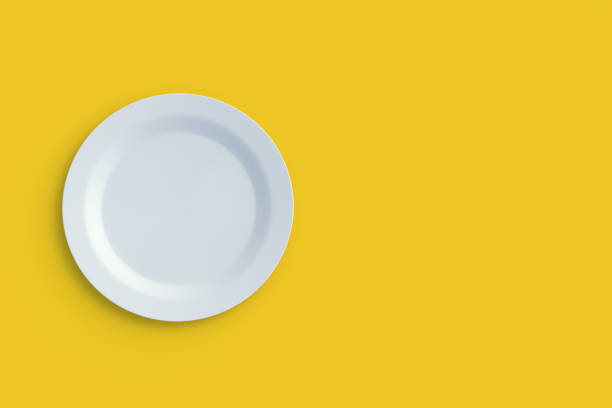 istock Round plate on yellow background. Top view. Copy space. 3d render 1395784946