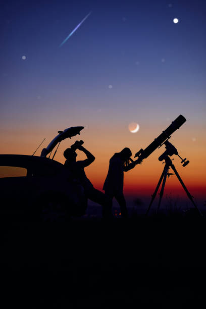 istock Couple stargazing together with a astronomical telescope. 1395787165