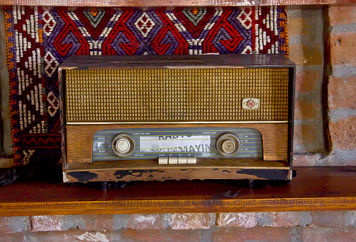 Retro broadcast radio receiver on wooden table in historical Turkish mud house at eastern Turkey, VAN