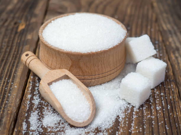 istock Stack of sugar cubes and granulated sugar in a wooden scoop 1395788498