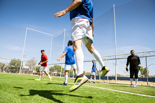 Soccer players jumping to hit the ball with their heads during a corner kick