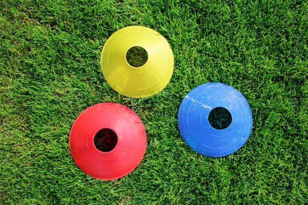 Photo of Soccer gears on green grass prepared for training in kids football academy. Popular sport activity