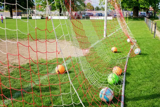 Photo of Soccer gears on green grass prepared for training in kids football academy. Popular sport activity