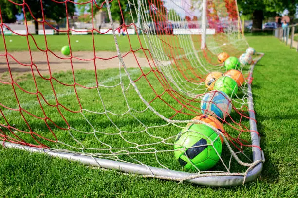 Photo of Soccer gears on green grass prepared for training in kids football academy. Popular sport activity