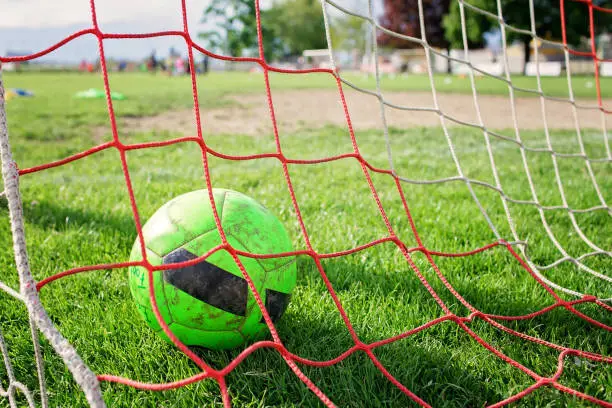 Photo of Soccer gears on green grass prepared for training in kids football academy. Popular sport activity