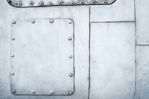 Close-up blue painted metal sheets with screw and rivets, background texture, dots, part of old airplane