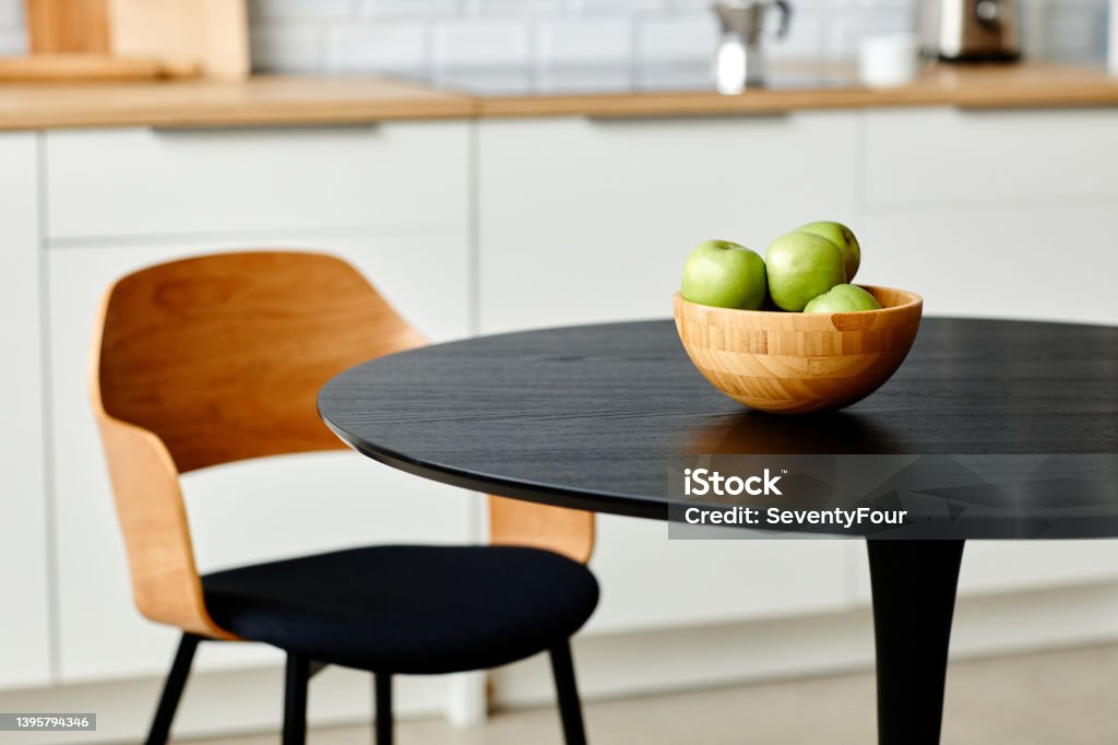 Minimal Kitchen Composition Minimal background image of fresh green apples in wooden vase on black kitchen table, copy space Dining Table Stock Photo