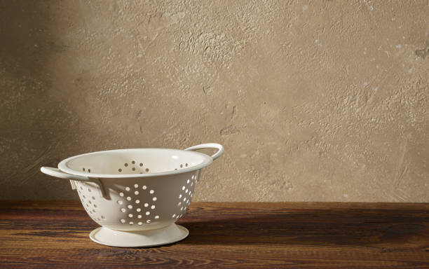 white metal strainer on wooden shelf